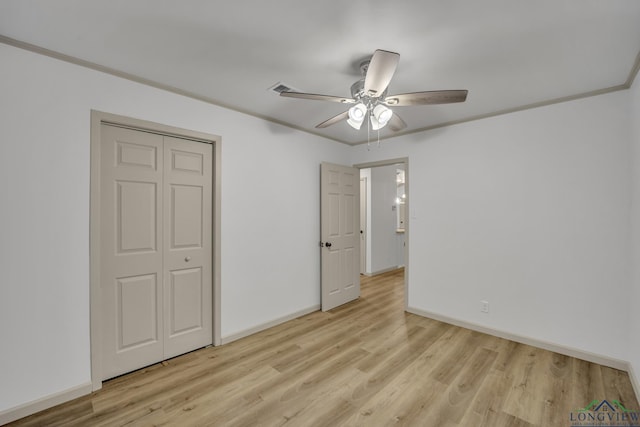 unfurnished bedroom with ceiling fan, a closet, crown molding, and light hardwood / wood-style floors