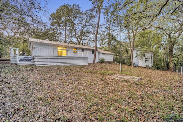 rear view of house with a storage unit