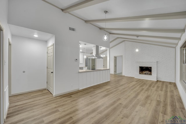 unfurnished living room featuring a fireplace, vaulted ceiling with beams, and light hardwood / wood-style flooring