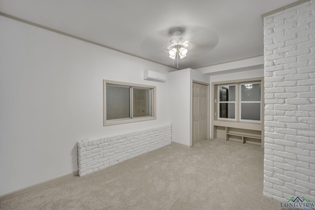 spare room featuring a wall unit AC, light carpet, ceiling fan, and ornamental molding