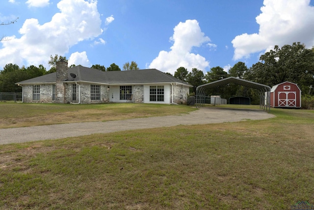 ranch-style home with a carport, an outdoor structure, and a front lawn