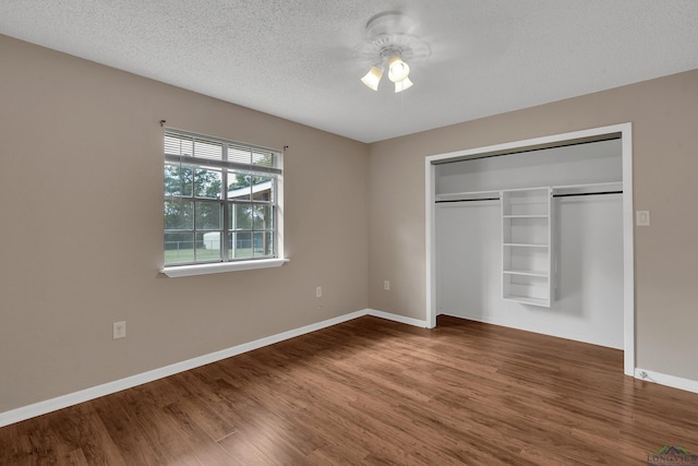 unfurnished bedroom featuring hardwood / wood-style floors, a textured ceiling, and a closet