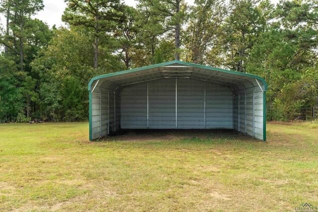 garage with a carport and a yard