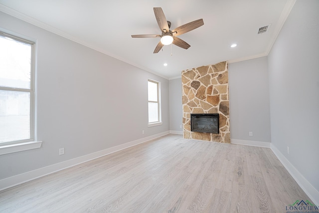 unfurnished living room with crown molding, ceiling fan, a fireplace, and light hardwood / wood-style flooring