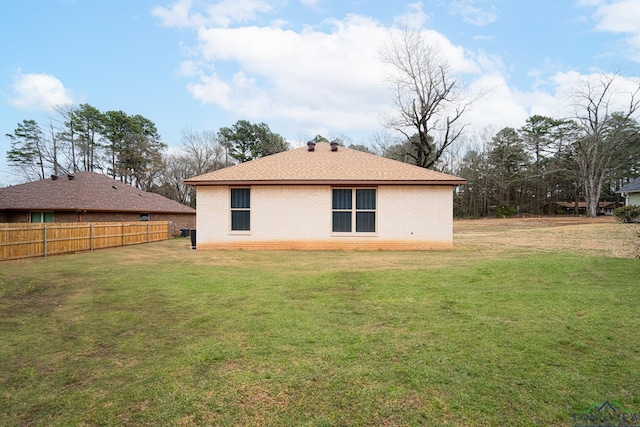 rear view of property featuring a lawn