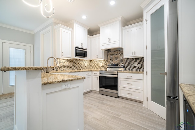 kitchen with sink, light stone counters, stainless steel appliances, decorative backsplash, and white cabinets