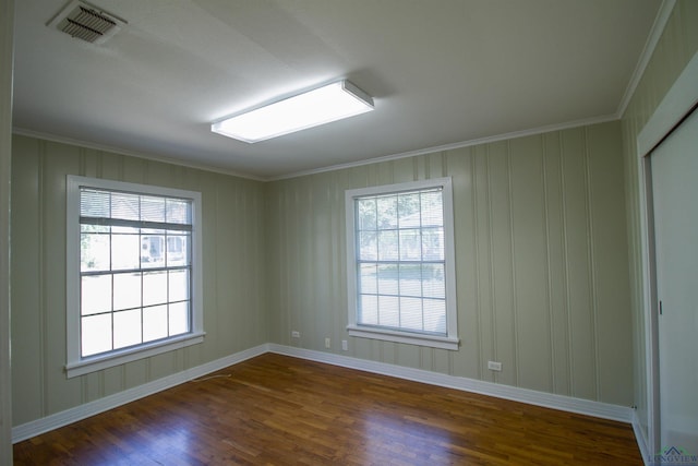 empty room featuring dark hardwood / wood-style floors and crown molding