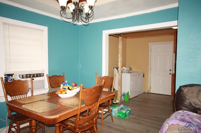 dining area featuring a notable chandelier, washing machine and dryer, and dark wood-type flooring