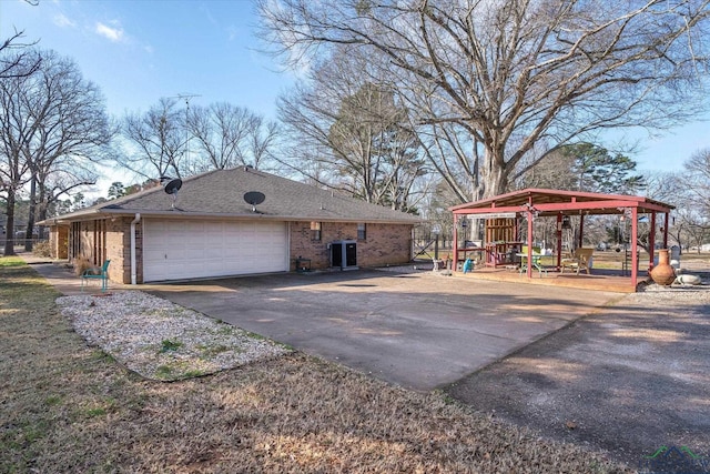 view of home's exterior featuring brick siding, roof with shingles, a gazebo, cooling unit, and driveway