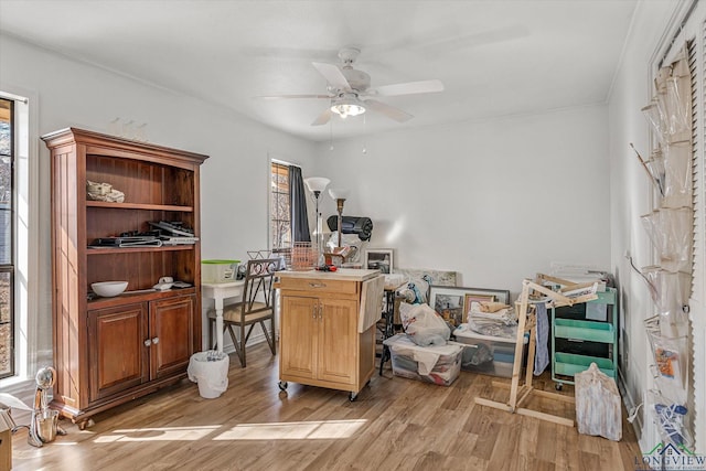 office area with light wood-style floors and a ceiling fan