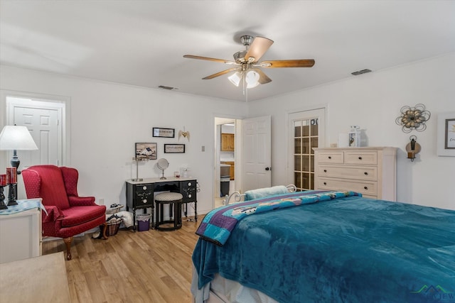 bedroom featuring visible vents, ceiling fan, and light wood-style flooring