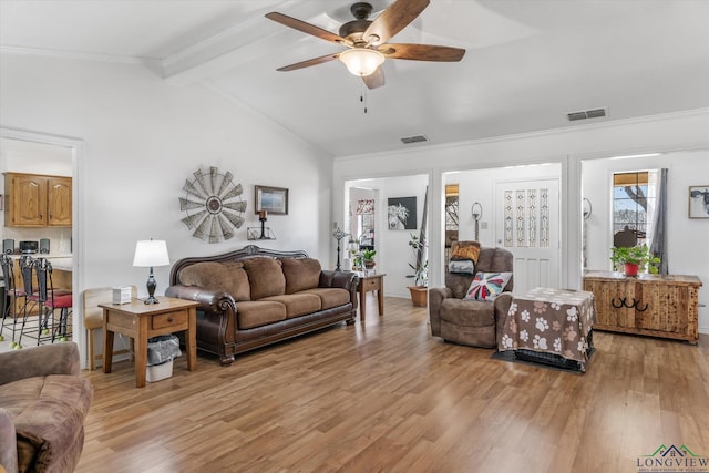 living area featuring lofted ceiling with beams, light wood-type flooring, visible vents, and a ceiling fan