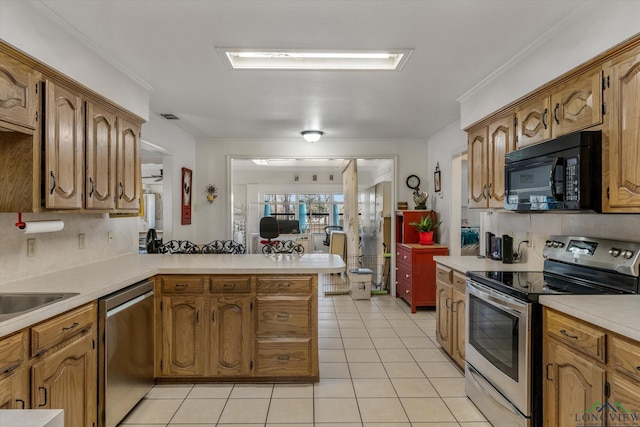 kitchen with crown molding, light tile patterned floors, light countertops, appliances with stainless steel finishes, and a peninsula