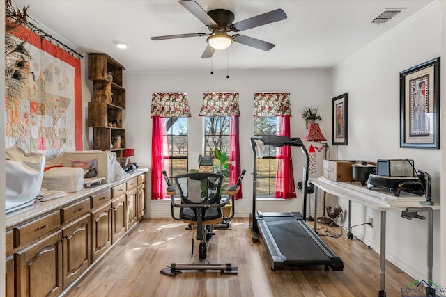 exercise area featuring ceiling fan, light wood-type flooring, visible vents, and baseboards