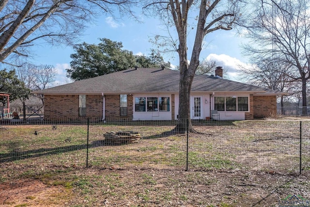 view of front of property with brick siding, fence, a chimney, and roof with shingles