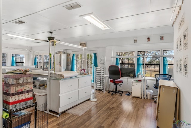 office area with plenty of natural light, visible vents, and wood finished floors