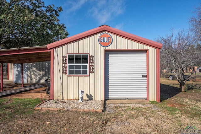 view of outdoor structure featuring a carport and an outbuilding