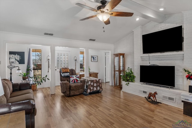 living area featuring vaulted ceiling with beams, wood finished floors, and visible vents