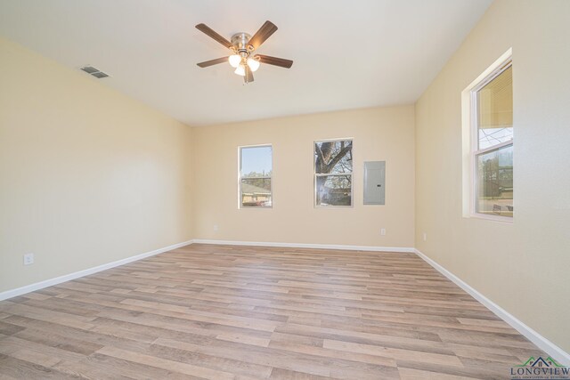 1104 N Bolivar St, Marshall, TX 75670 - unfurnished room featuring visible vents, electric panel, baseboards, a ceiling fan, and light wood-type flooring