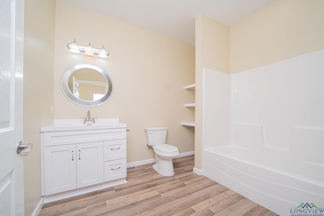1104 N Bolivar St, Marshall, TX 75670 - bathroom featuring shower / bathing tub combination, vanity, toilet, baseboards, and wood finished floors