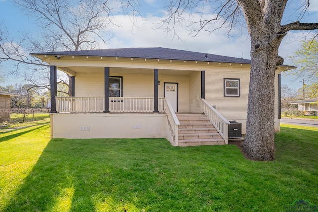 1104 N Bolivar St, Marshall, TX 75670 - view of front of home with cooling unit, a front yard, covered porch, and roof with shingles