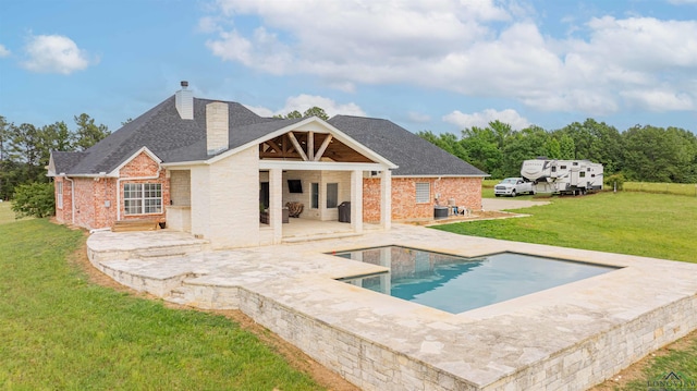 20064 Fm 1716 E, Tatum, TX 75691 - back of house featuring roof with shingles, brick siding, a patio, a chimney, and a lawn