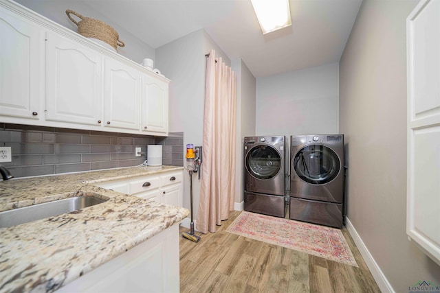 20064 Fm 1716 E, Tatum, TX 75691 - laundry room with a sink, cabinet space, washer and dryer, light wood finished floors, and baseboards