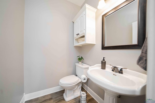 20064 Fm 1716 E, Tatum, TX 75691 - half bath with baseboards, toilet, a sink, and wood finished floors