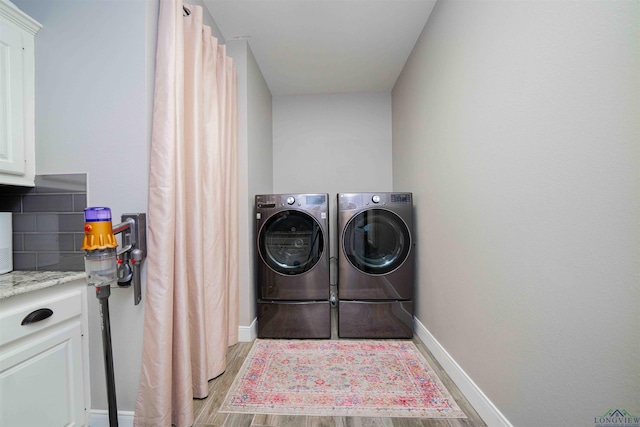 20064 Fm 1716 E, Tatum, TX 75691 - washroom featuring cabinet space, washing machine and clothes dryer, light wood-style floors, and baseboards
