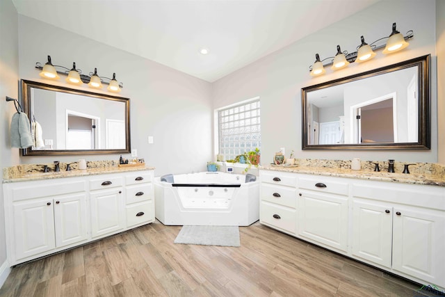 20064 Fm 1716 E, Tatum, TX 75691 - full bathroom with a sink, two vanities, a bath, and wood finished floors