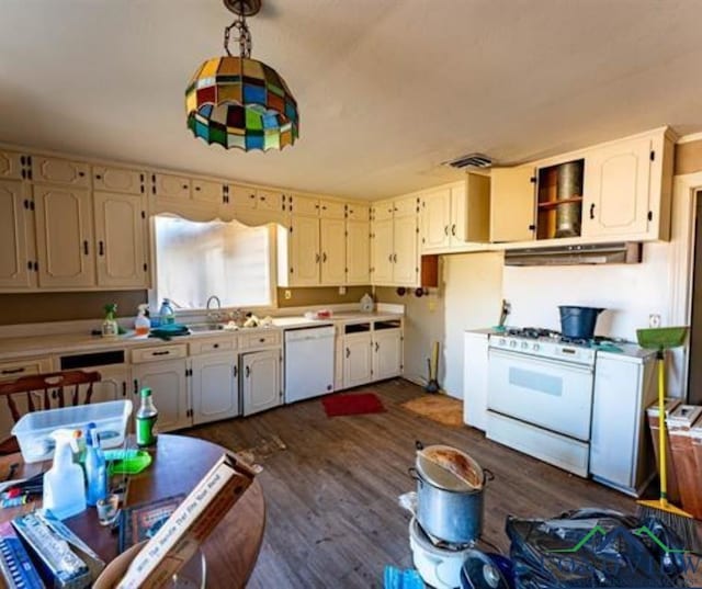 kitchen featuring under cabinet range hood, white appliances, visible vents, light countertops, and dark wood finished floors