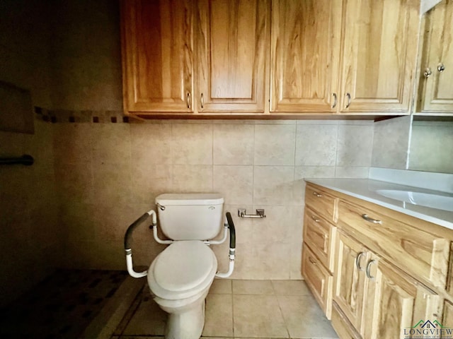bathroom with toilet, vanity, and tile patterned floors