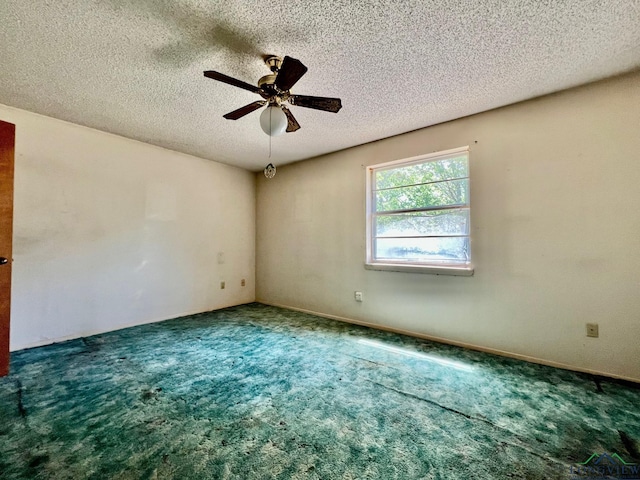 carpeted empty room with a textured ceiling and ceiling fan