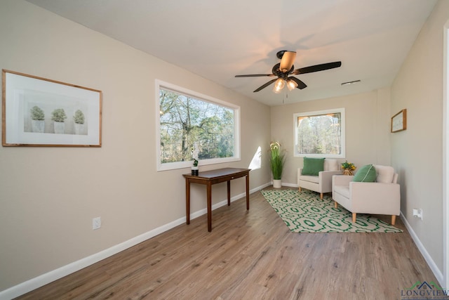 sitting room featuring light hardwood / wood-style floors and ceiling fan