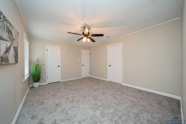 carpeted empty room featuring ornamental molding and ceiling fan