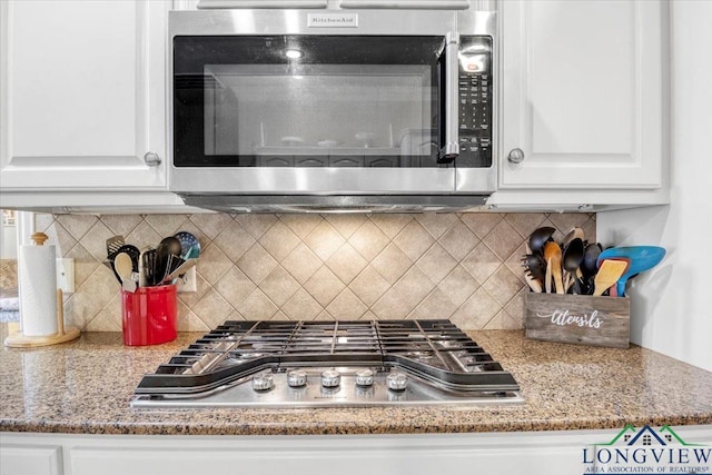 1900 Frostwood Dr, Tyler, TX 75703 - interior details featuring light stone counters, tasteful backsplash, appliances with stainless steel finishes, and white cabinetry