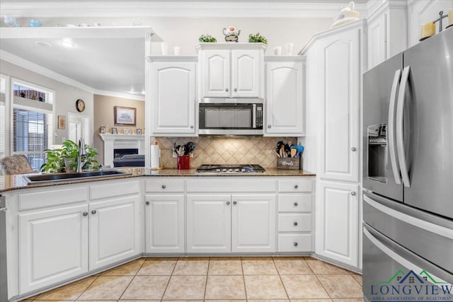 1900 Frostwood Dr, Tyler, TX 75703 - kitchen with white cabinetry, crown molding, a sink, appliances with stainless steel finishes, and backsplash
