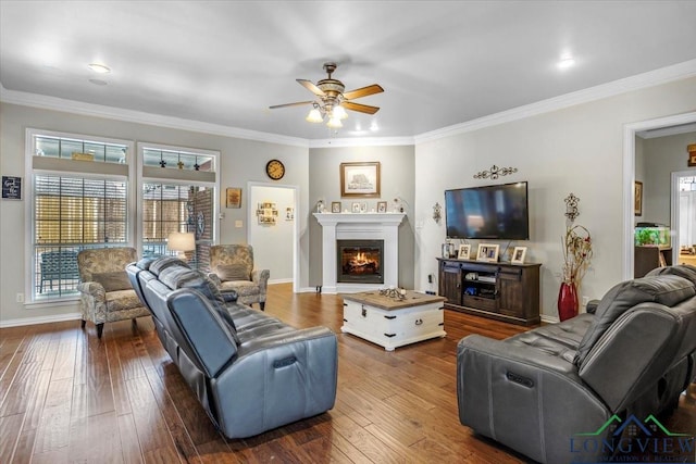 1900 Frostwood Dr, Tyler, TX 75703 - living area featuring crown molding, dark wood-style floors, a ceiling fan, and a lit fireplace