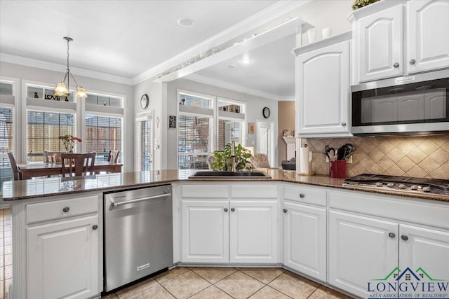 1900 Frostwood Dr, Tyler, TX 75703 - kitchen featuring a sink, stainless steel appliances, dark stone countertops, crown molding, and backsplash