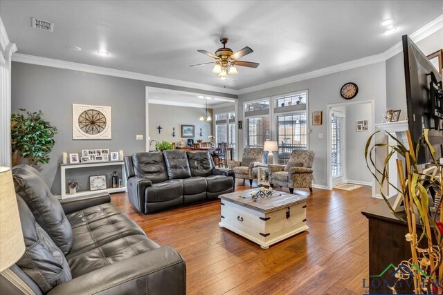 1900 Frostwood Dr, Tyler, TX 75703 - living area with ceiling fan, wood-type flooring, baseboards, visible vents, and crown molding
