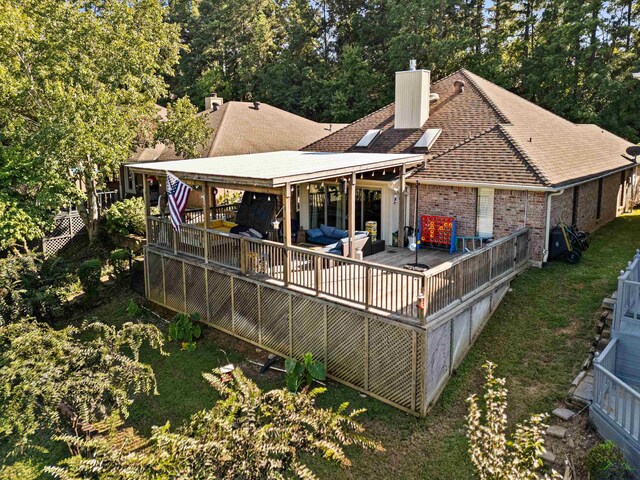 back of property featuring a lawn and a deck