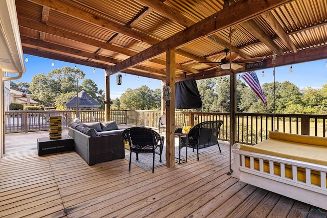 wooden terrace with an outdoor living space and ceiling fan