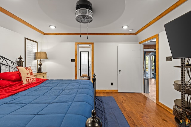 bedroom featuring hardwood / wood-style flooring, ceiling fan, crown molding, and multiple windows