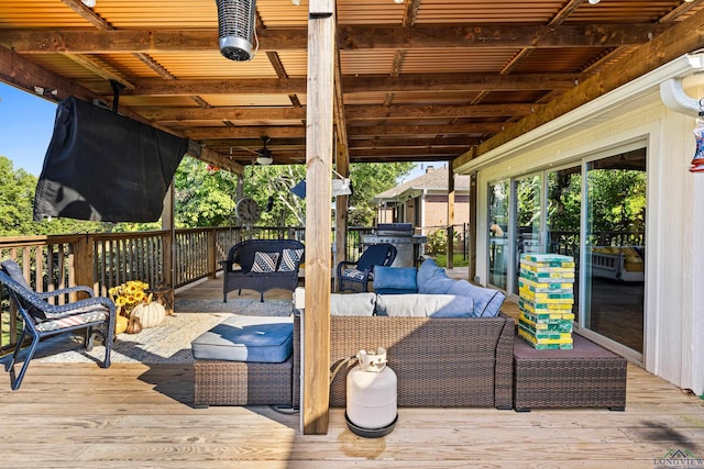 wooden deck with an outdoor living space and a grill