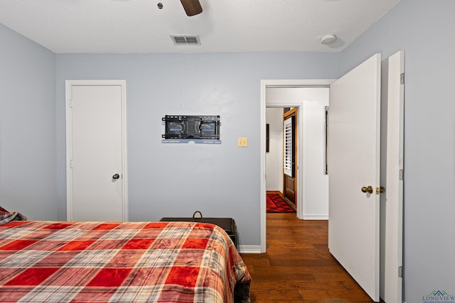 bedroom featuring a textured ceiling, dark hardwood / wood-style flooring, and ceiling fan