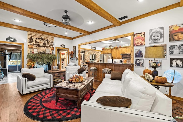 living room with beam ceiling, light wood-type flooring, and ceiling fan