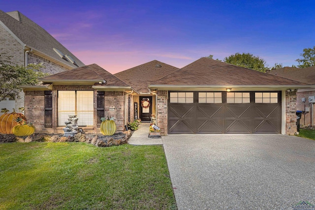 view of front of property featuring a garage and a lawn