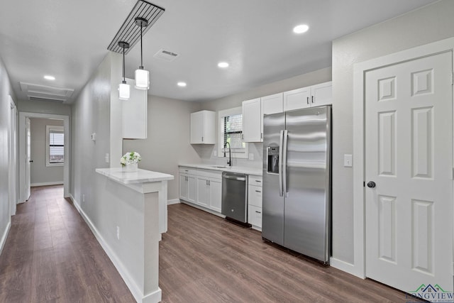251 Crockett St, Lone Star, TX 75668 - kitchen featuring appliances with stainless steel finishes, light countertops, white cabinetry, dark wood-type flooring, and hanging light fixtures