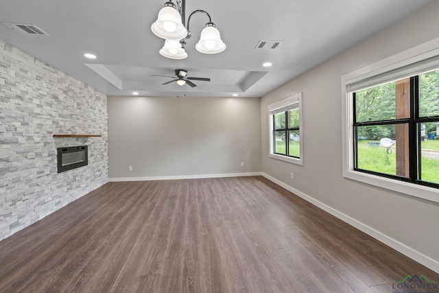 251 Crockett St, Lone Star, TX 75668 - unfurnished living room with a raised ceiling, a stone fireplace, dark wood-style flooring, ceiling fan, and recessed lighting