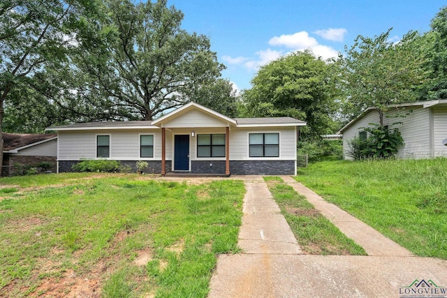 251 Crockett St, Lone Star, TX 75668 - view of front of home with stone siding, a front yard, and a porch